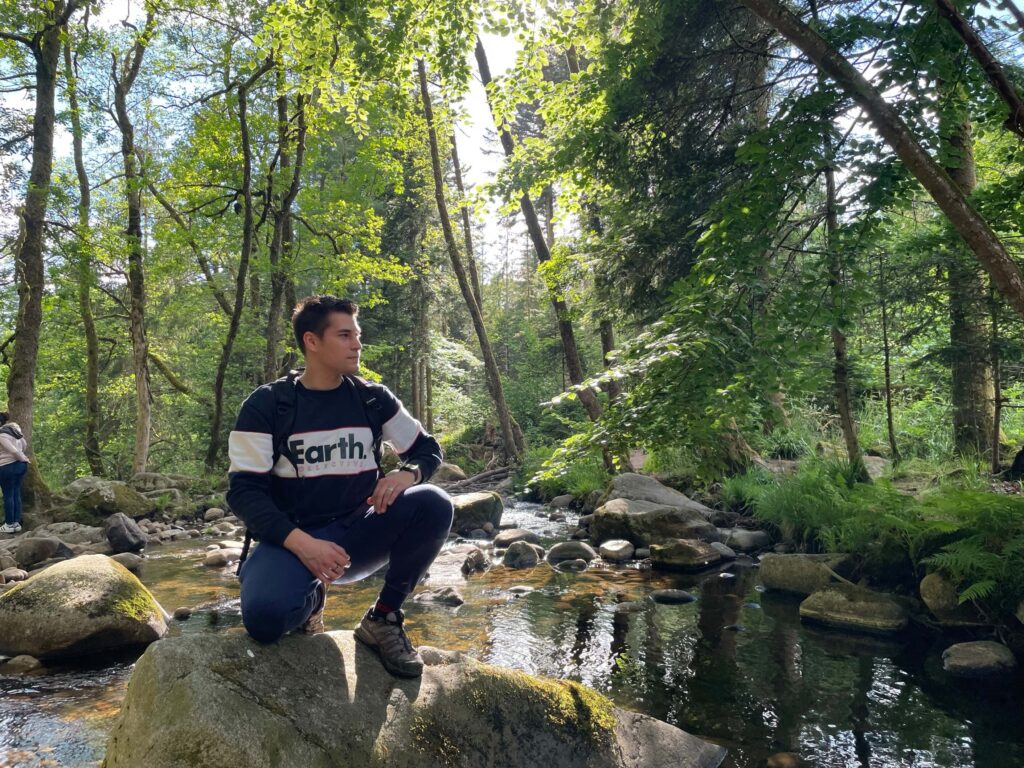 Benjamin Perrin is trecking next to a river